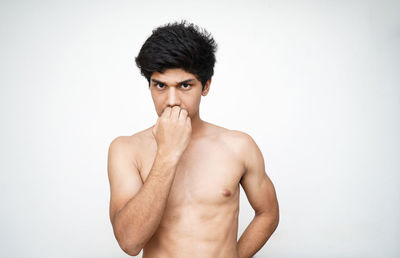 Portrait of shirtless man against white background