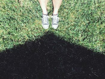 Low section of woman standing on field