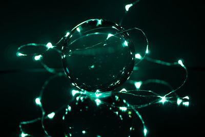 Close-up of illuminated glass over black background