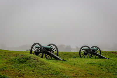 Cannons on field against sky