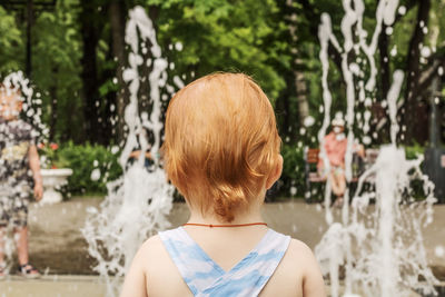 Rear view of girl against fountain