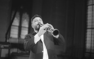 Man playing clarinet while standing at studio