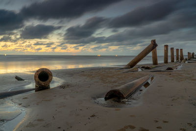 Abandoned sand on beach against sky during sunset