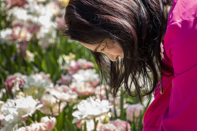 Close-up of woman with pink flowering plants