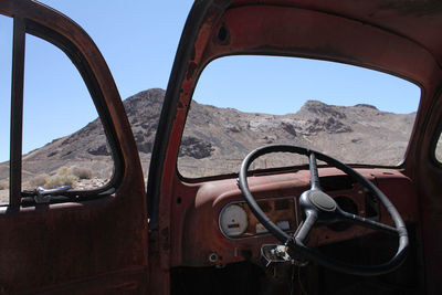 Abandoned car in death valley, california, with the steering wheel in the foreground