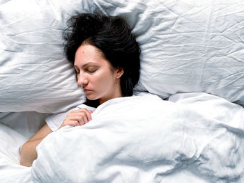 High angle view of woman sleeping on bed at home