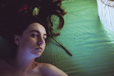 High angle view of young woman relaxing on bed at home