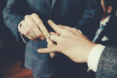 Gay men exchanging rings at wedding ceremony