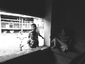 Woman looking through window at home