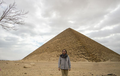 Full length of man standing on sand against sky