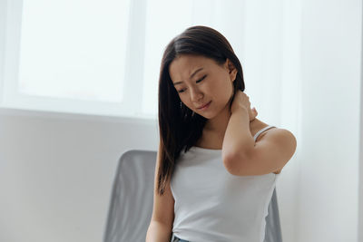 Frustrated young woman suffering from neck pain