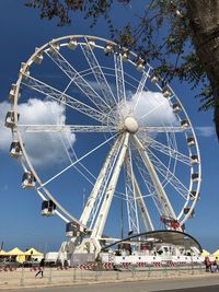 Low angle view of ferris wheel against blue sky