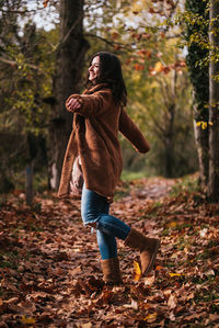 Rear view of woman standing in forest