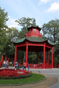 Gazebo in park by building against sky