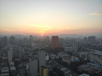 High angle view of modern buildings against sky during sunset