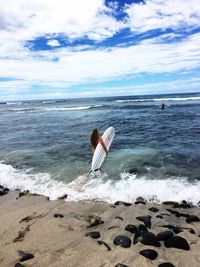 Rear view of person on beach against sky