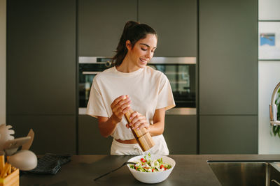 Woman holding food while standing at home