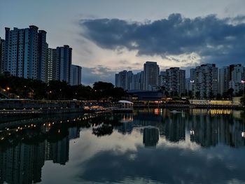 Reflection of illuminated buildings in city at dusk