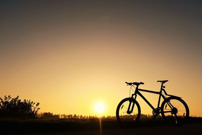 Silhouette bicycle against sky during sunset