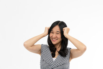 Portrait of smiling young woman against white background