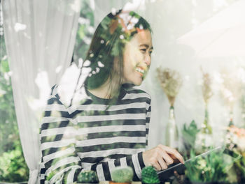 Close-up of young woman standing against plants