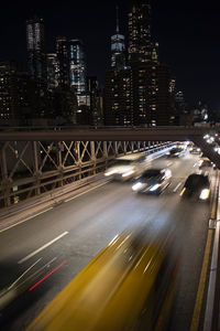 Blurred motion of cars on bridge in illuminated city at night