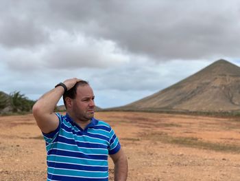 Man looking away against landscape and sky