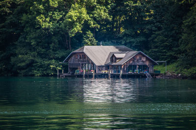 House by lake against trees in forest