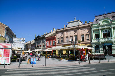 People on street against buildings in city