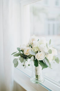 Close-up of white roses in vase on table