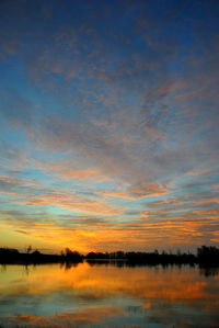 Scenic view of calm lake at sunset