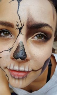 Close-up portrait of teenage girl with spooky make-up