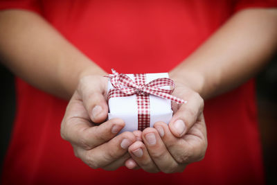 Close-up of human hand holding red box