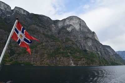 Scenic view of mountain by sea against sky