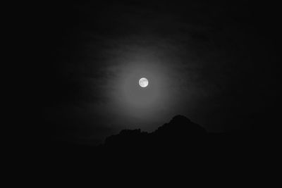 Low angle view of silhouette moon against sky at night