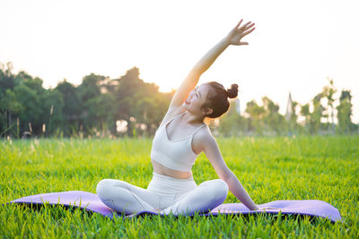 Side view of woman doing yoga at park