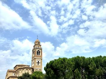 Low angle view of trees and building against sky