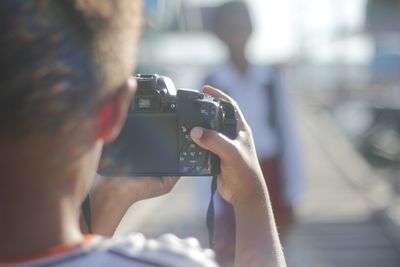 Close-up of man photographing camera on mobile phone