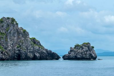 Rock formations in sea against sky