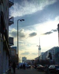 View of city street against cloudy sky