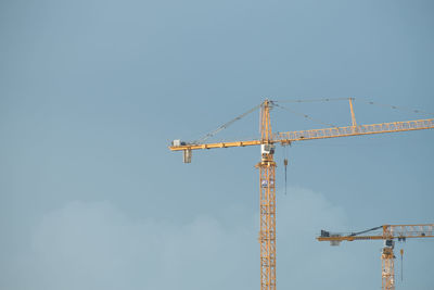 Low angle view of crane against clear sky