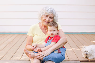 Portrait of grandmother sitting with grandson outdoors