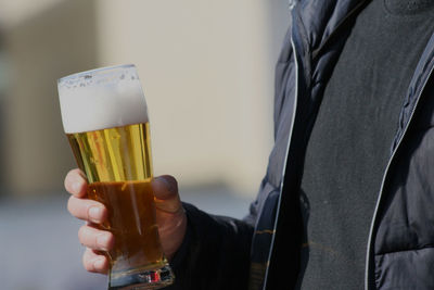 Close-up of man holding beer glass