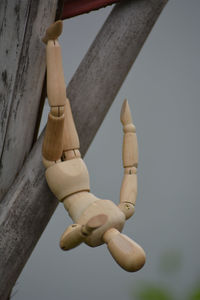 Low angle view of cross hanging on wood against wall