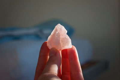 Holding a healing chrystal rose quartz for meditation, inner peace and heart opening