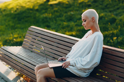 Woman sitting on bench in park