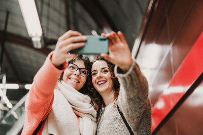 Portrait of smiling woman using mobile phone