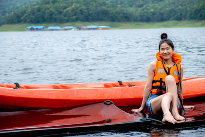 Portrait of smiling young woman sitting on boat