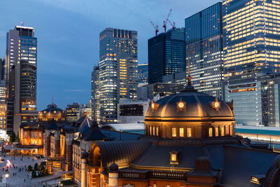 Illuminated buildings in city at dusk