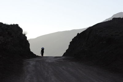 Man standing on mountain against clear sky